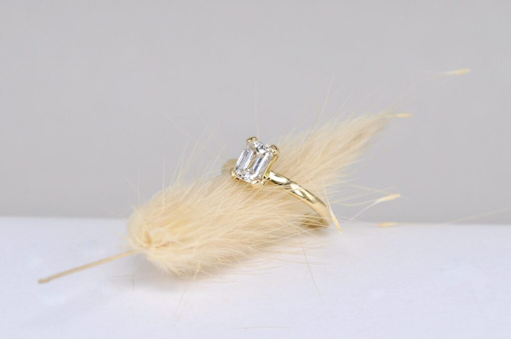 Individuell nach Kundenwunsch angefertigter Verlobungsring aus Echtgold von Goldschmiede Stephanie Berger mit einem edlen 1-Karat-Diamanten im Emerald-Schliff.