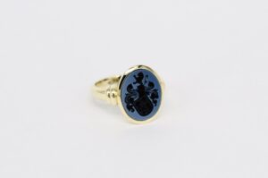 Exklusiver Damen-Siegelring aus Gold mit einer kunstvoll gestalteten Ringschiene und blauem Lagenstein
